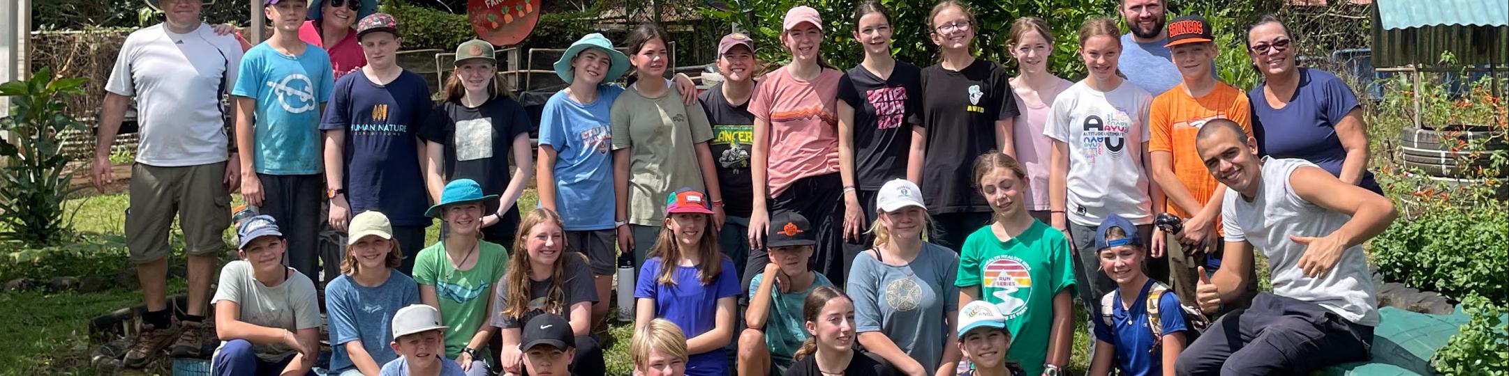 A group of middle school students and their teachers pose for a group picture in Costa Rica