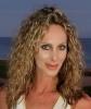 a picture of a lady with curly hair smiling at the camera