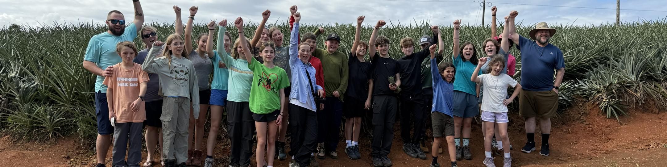 Students and staff stand in front of a pineapple farm in Costa Rica. 