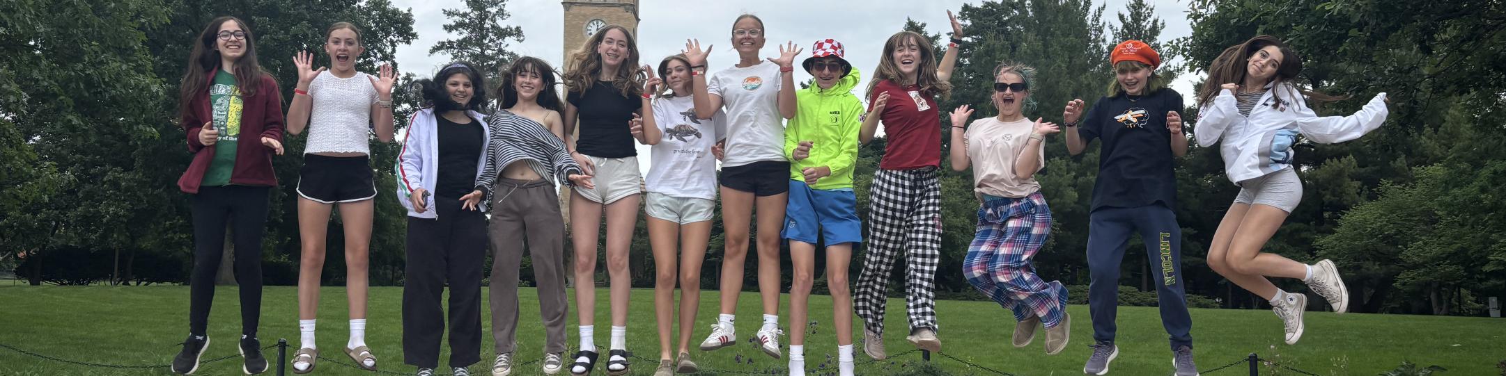 A group of middle school students are jumping up in the air in excitement. They are at Iowa State University for Odyssey of the Mind, World Competition.
