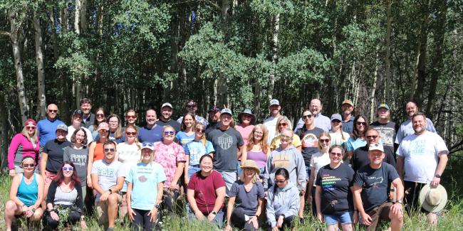 A large group of people standing in front of aspen trees