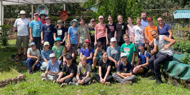 A group of middle school students and their teachers pose for a group picture in Costa Rica