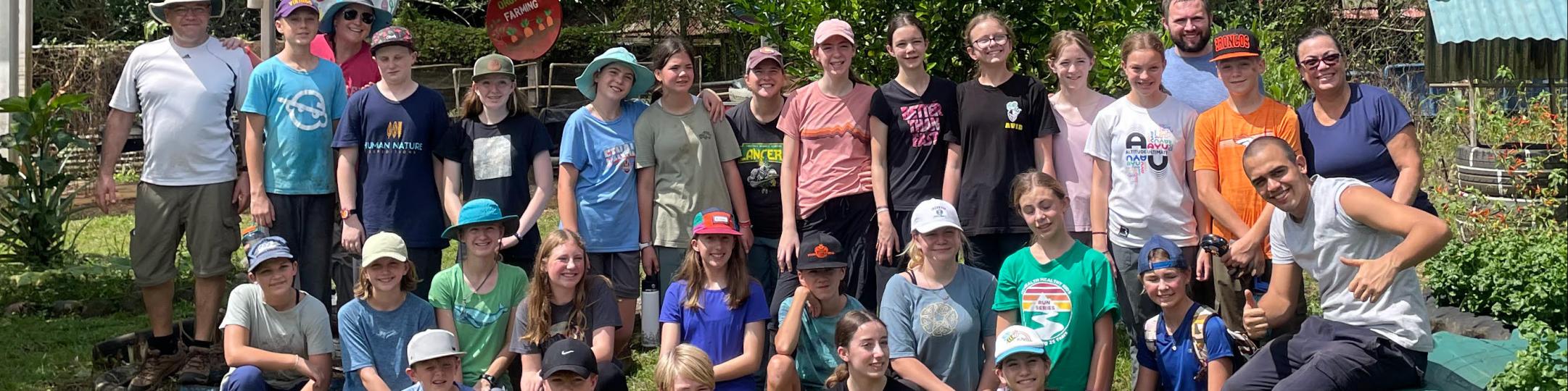 A group of middle school students and their teachers pose for a group picture in Costa Rica