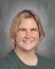 Female with blonde hair, a green shirt, and a gray background. 