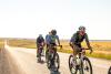 Male in green jersey riding in a group of cyclists.