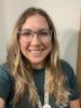 A picture of Ms. Guilbert with long hair and glasses. 